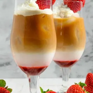 Easy Iced Strawberry Latte topped with whipped cream and a fresh strawberry.