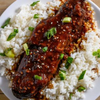 Asian Country Style Ribs over rice on a plate.