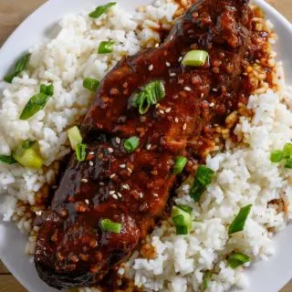 Asian Country Style Ribs over rice on a plate.