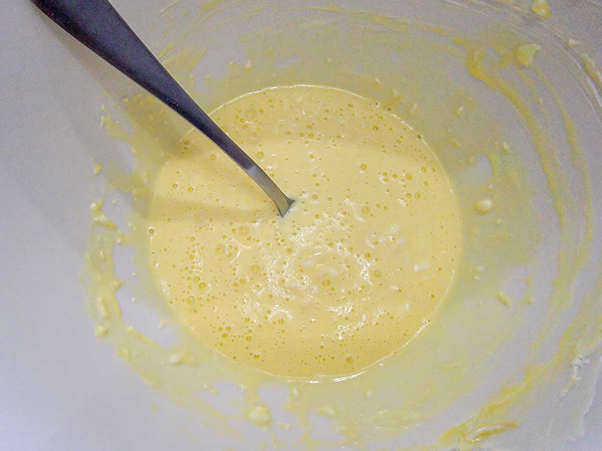 egg, parmesan cheese, and cream cheese mixed in a bowl.