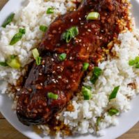 Asian Country Style Ribs over rice on a plate.