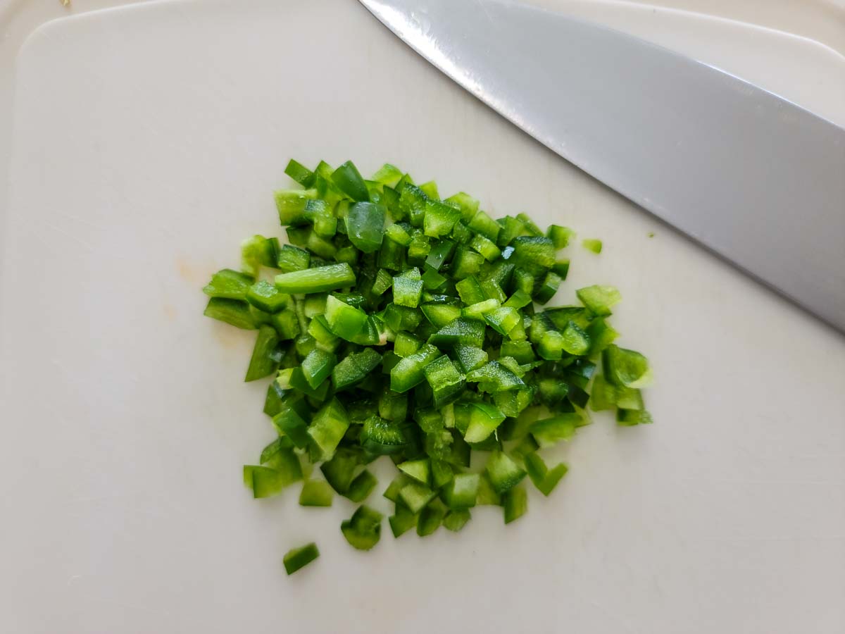 jalapeno pepper diced on a cutting board.