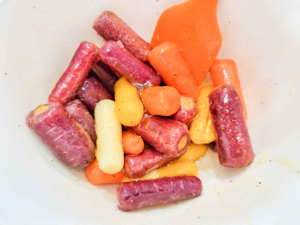 carrots, honey, and olive oil mixed in a bowl.