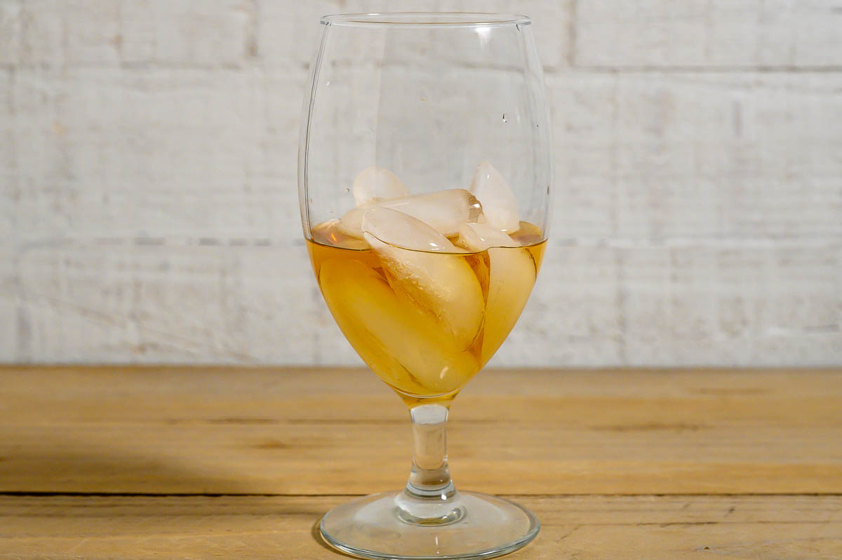 peanut butter whiskey and ice in a tall glass.