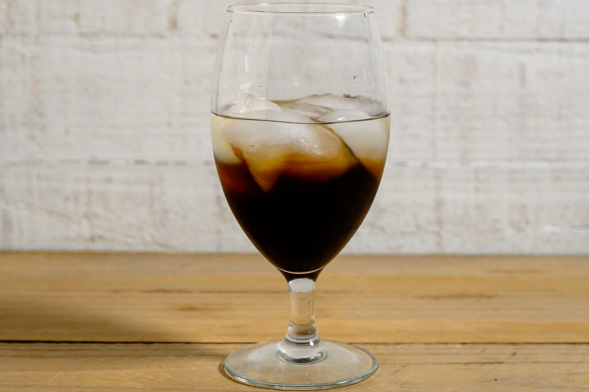 Kahlua liqueur, vodka, peanut butter whiskey, and ice in a tall glass.