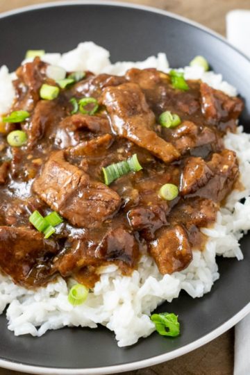 Crock Pot Mongolian Beef over rice on a plate.