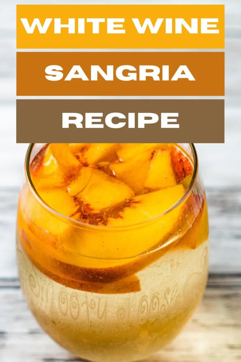 White Wine Sangria in a glass with peaches.