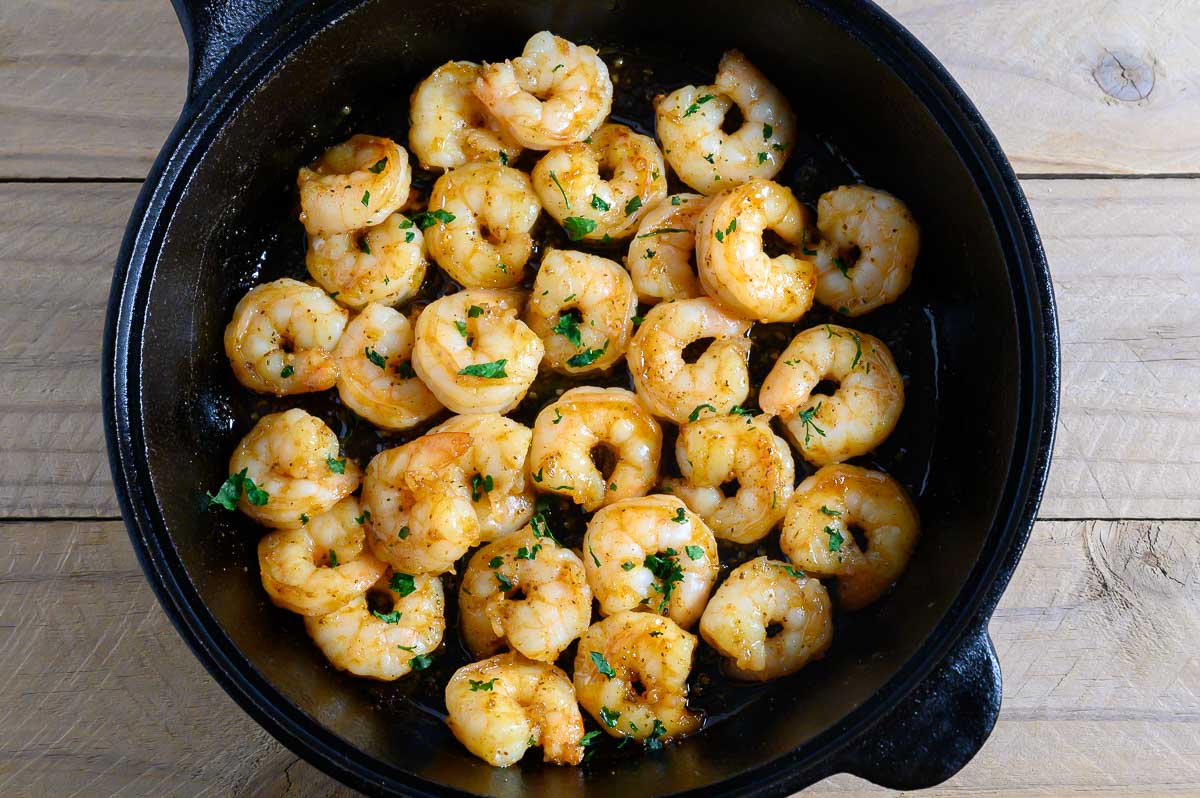 Honey Butter Old Bay Shrimp in a cast iron skillet.