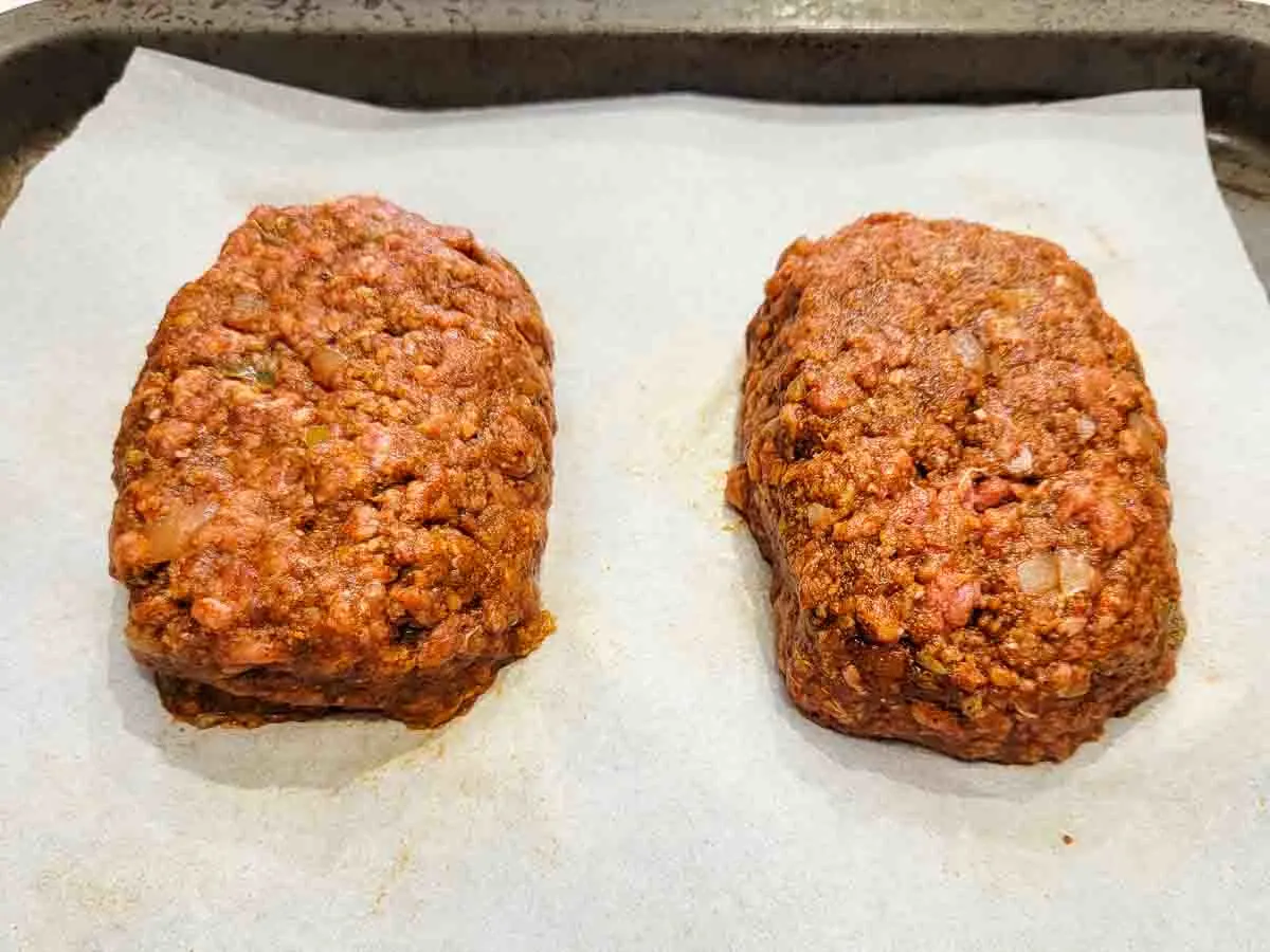 two unbaked taco meatloaves on a baking sheet.