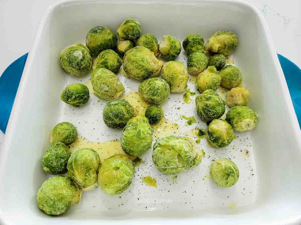 brussels sprouts and oil in a casserole dish.