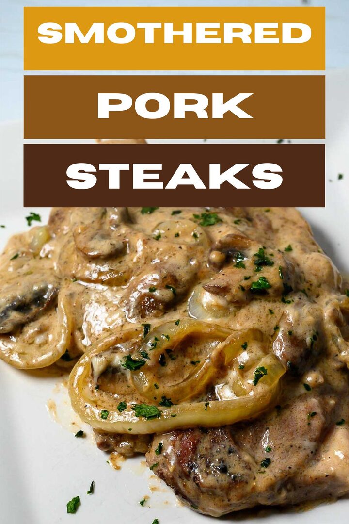 smothered pork steaks on a plate.