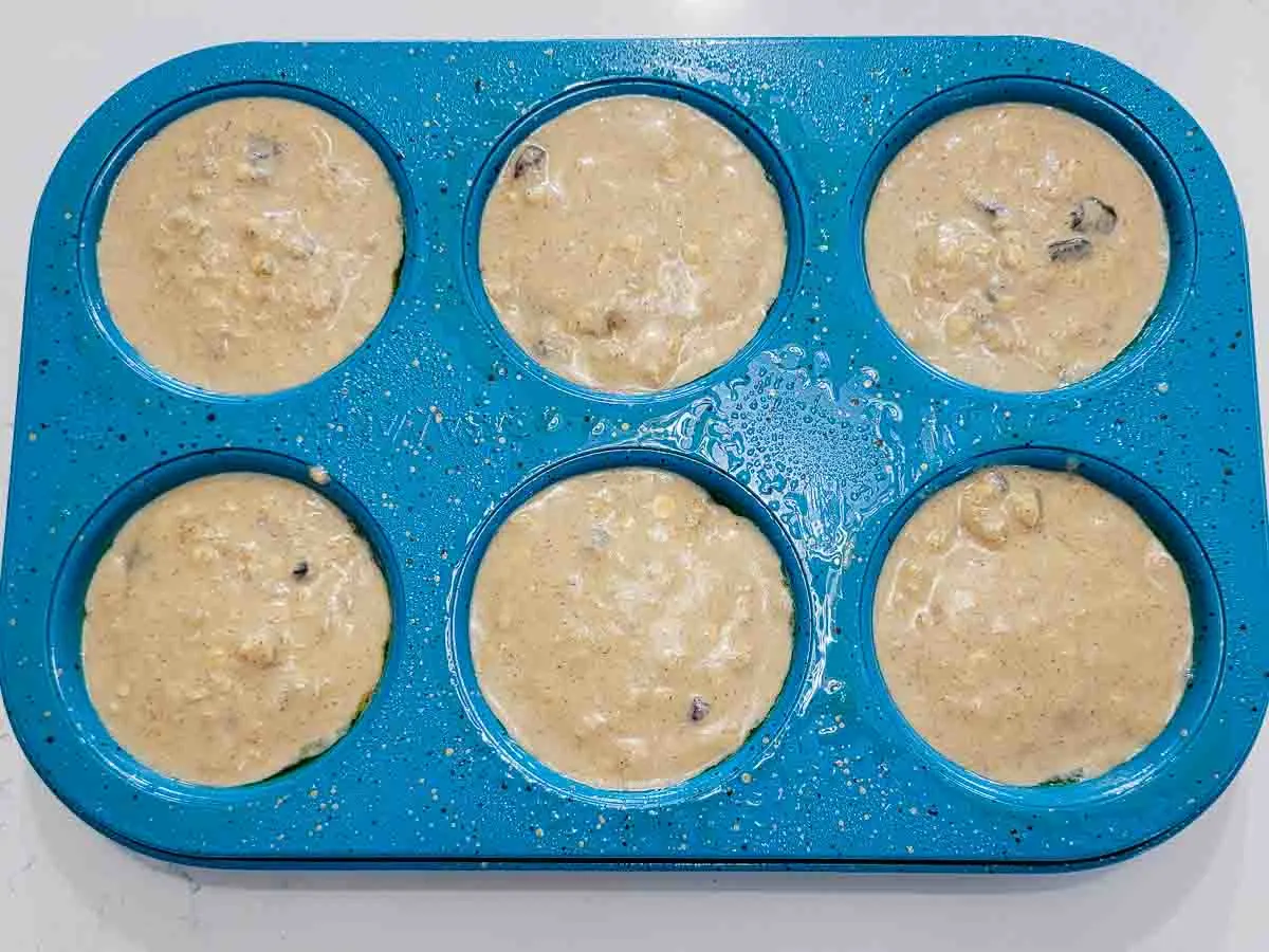 raisin muffin batter in 6 cups of a muffin tin.