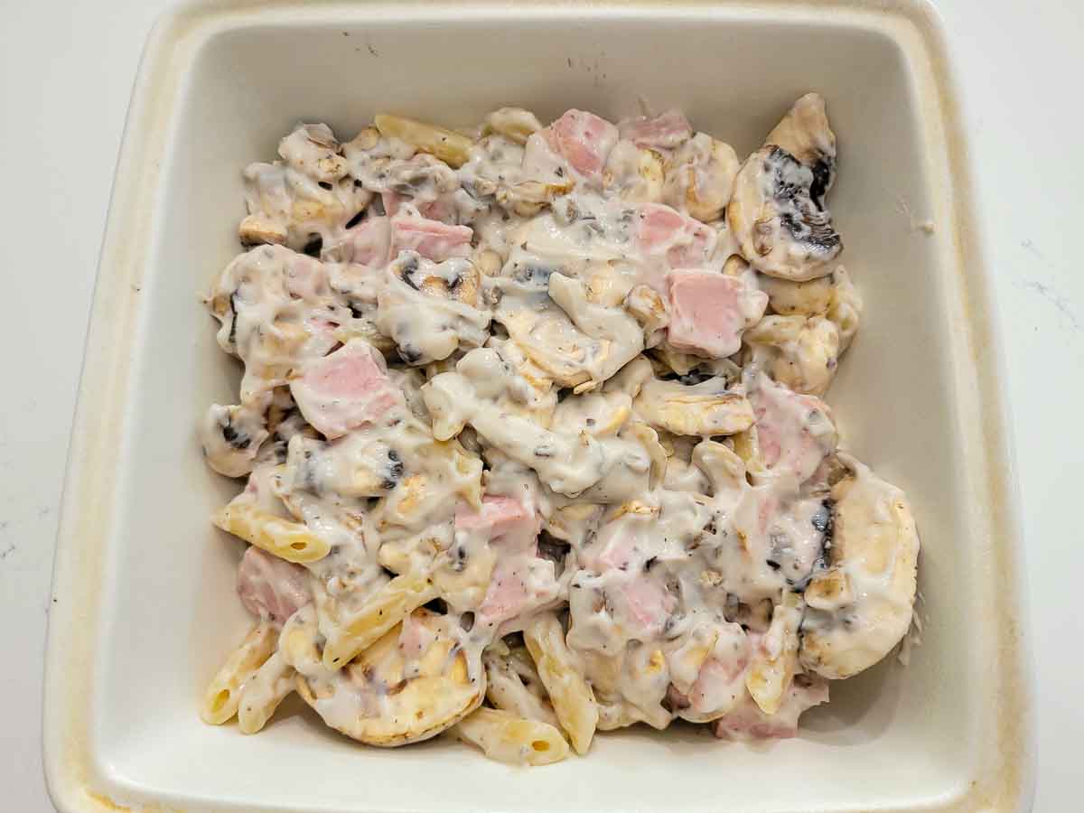 pasta, mushrooms, spam, and cream of mushroom soup in a baking dish.