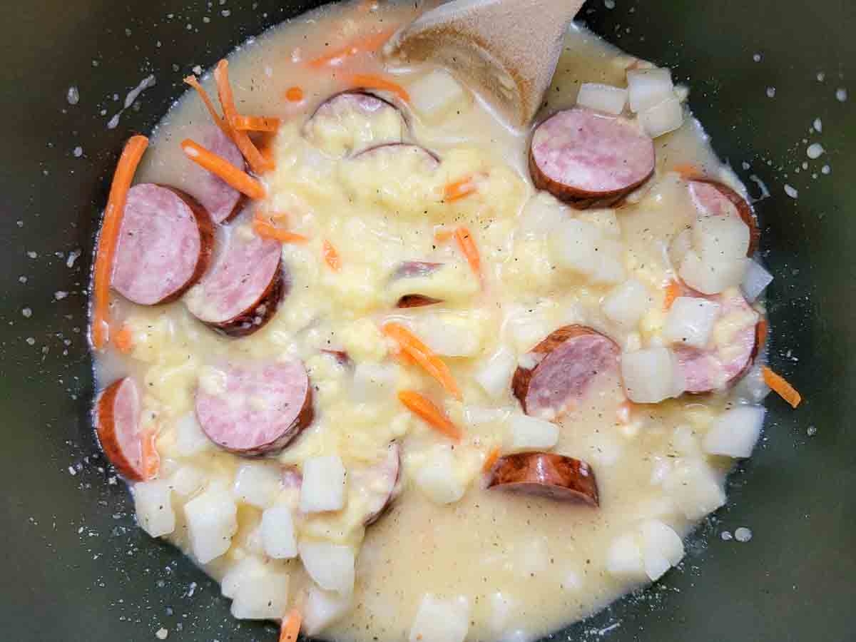 sliced kielbasa, carrots, the minced garlic, cream of chicken soup, hash brown potatoes, beer, salt, and pepper in a saucepan.