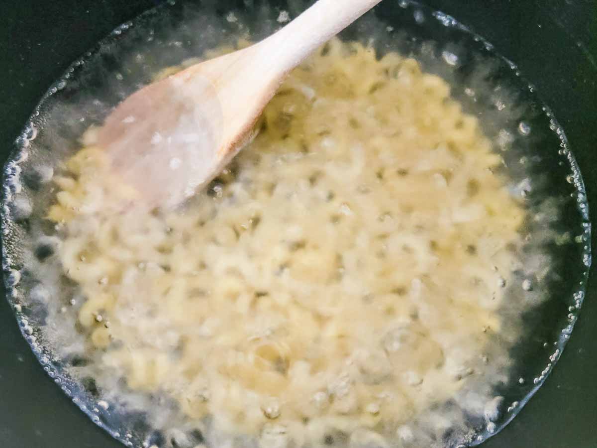 elbow noodles cooking in a pan.