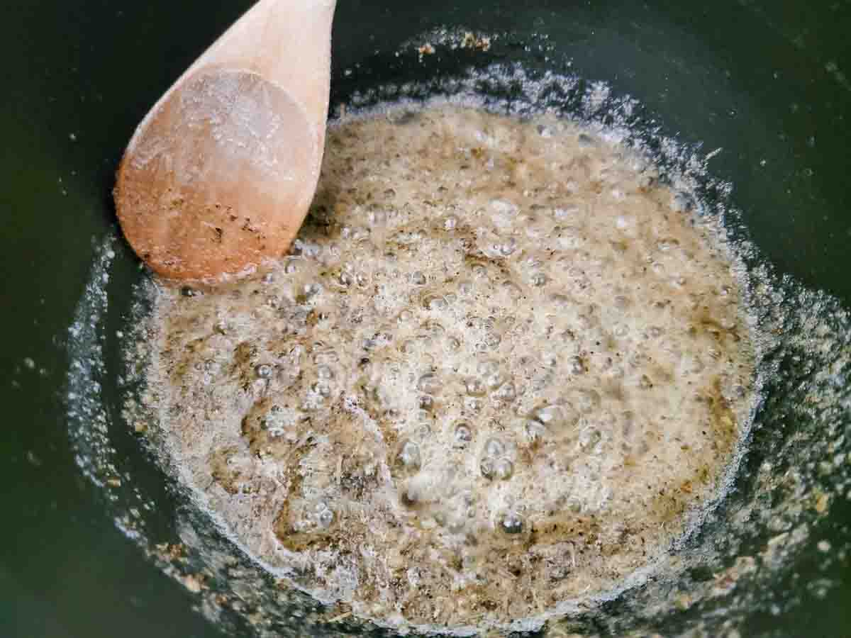 butter, garlic, salt, pepper, onion powder, and Italian seasoning cooking in a pan.