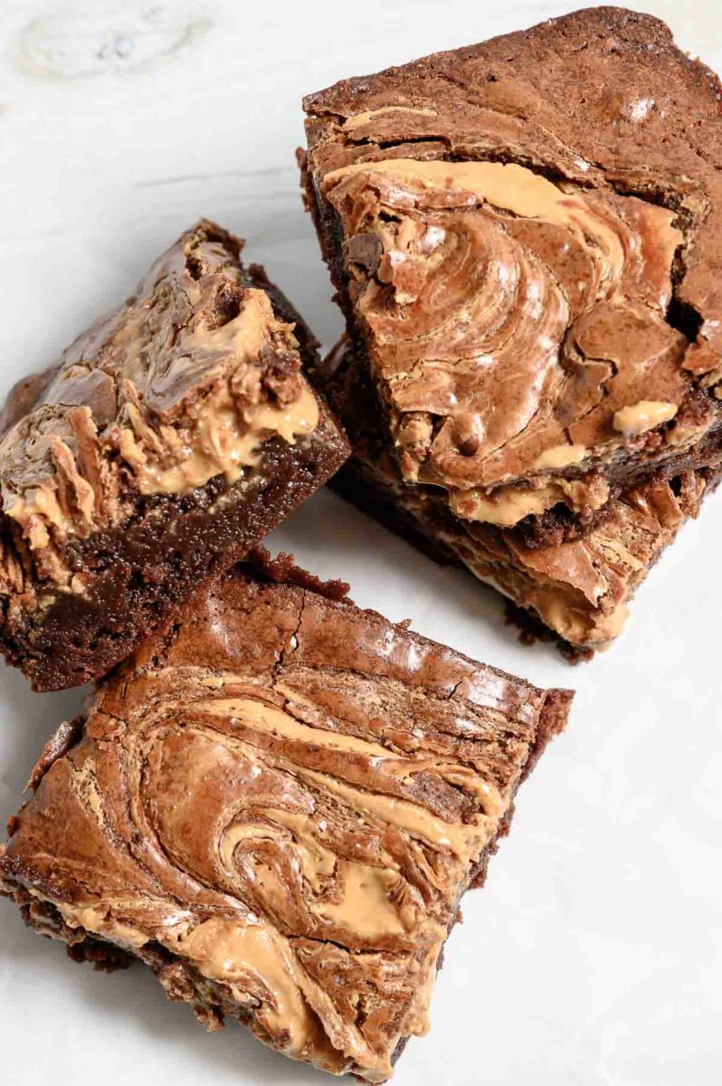 Peanut Butter Brownies stacked on parchment paper.