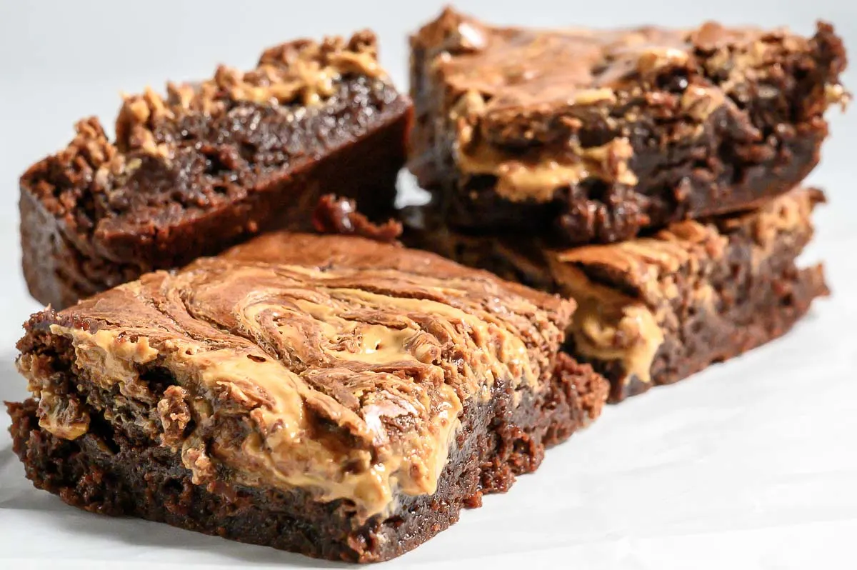 Peanut Butter Brownies stacked on parchment paper.