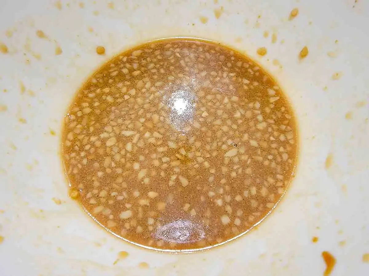 minced garlic, ground ginger, soy sauce, oyster sauce, cornstarch, brown sugar, sesame oil, and chicken broth mixed in a bowl.