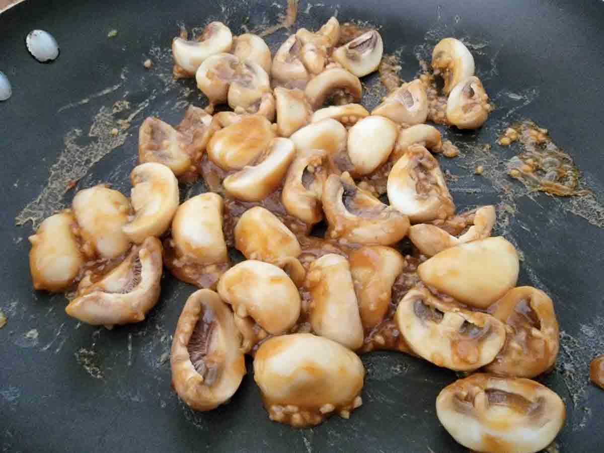 minced garlic, ground ginger, soy sauce, oyster sauce, cornstarch, brown sugar, sesame oil, and chicken broth, and button mushrooms frying in a pan.