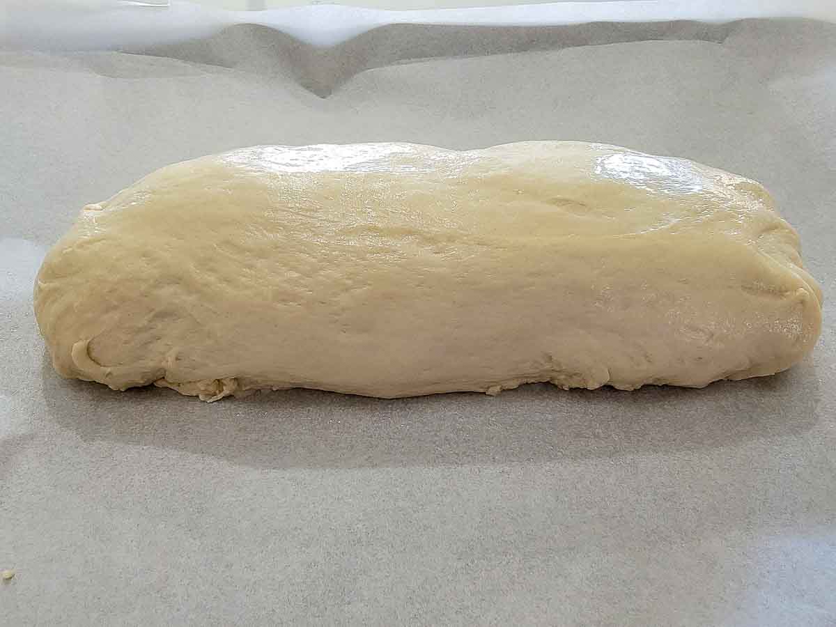 bread dough shaped into a loaf on a baking sheet.