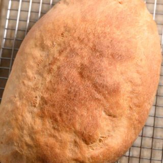 6 Ingredient Italian Bread on a cooling rack and baking sheet.