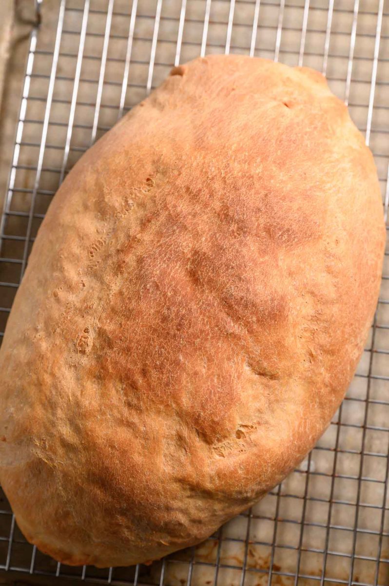 6 Ingredient Italian Bread on a cooling rack and baking sheet.