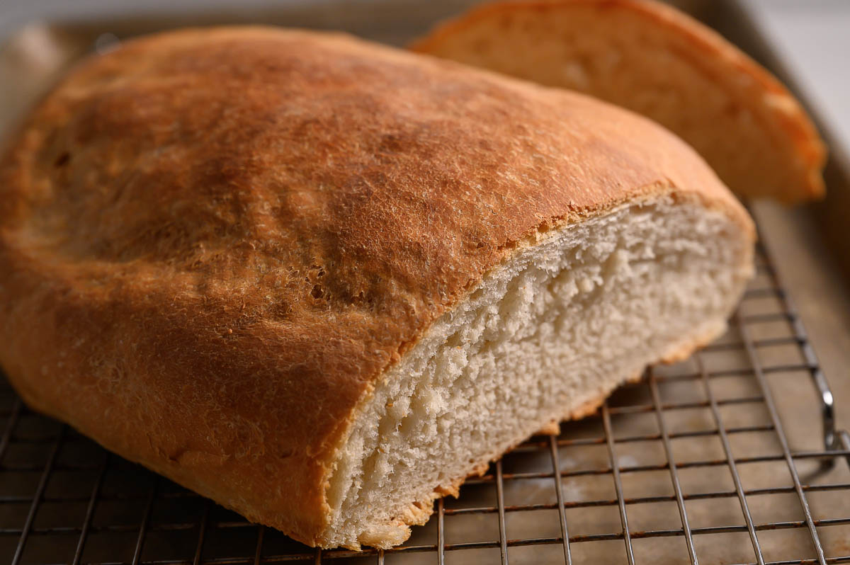 6 Ingredient Italian Bread on a cooling rack and baking sheet.