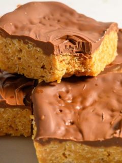 butterscotch chocolate peanut butter rice krispie bars stacked on a plate.