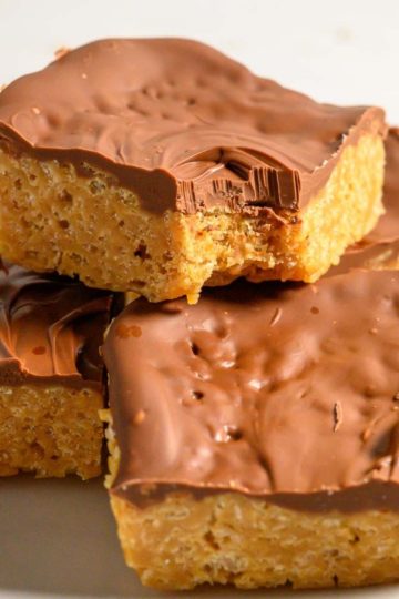 butterscotch chocolate peanut butter rice krispie bars stacked on a plate.