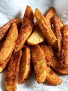 Battered Potato Wedges on paper towel.