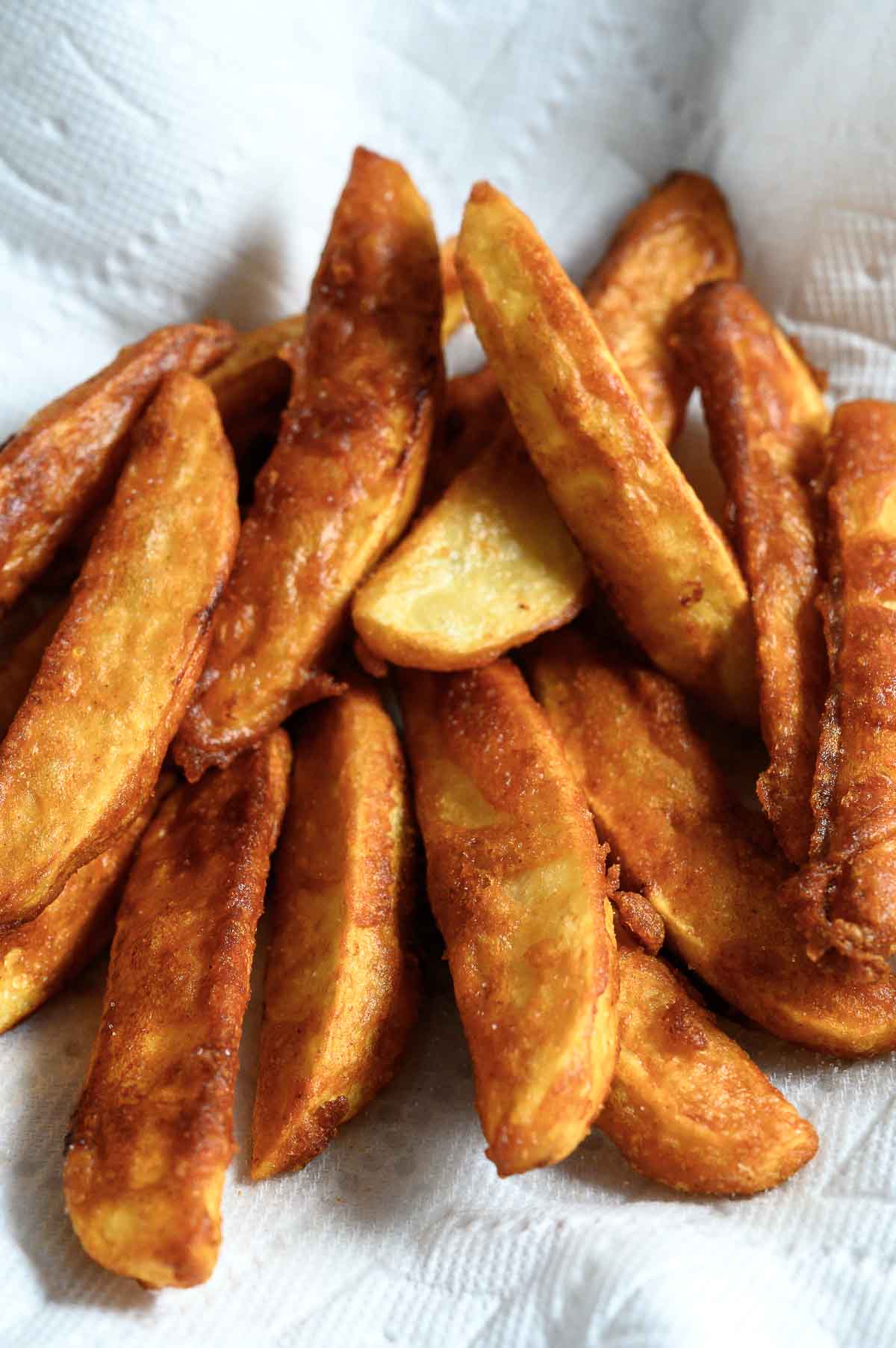 Battered Potato Wedges on paper towel.