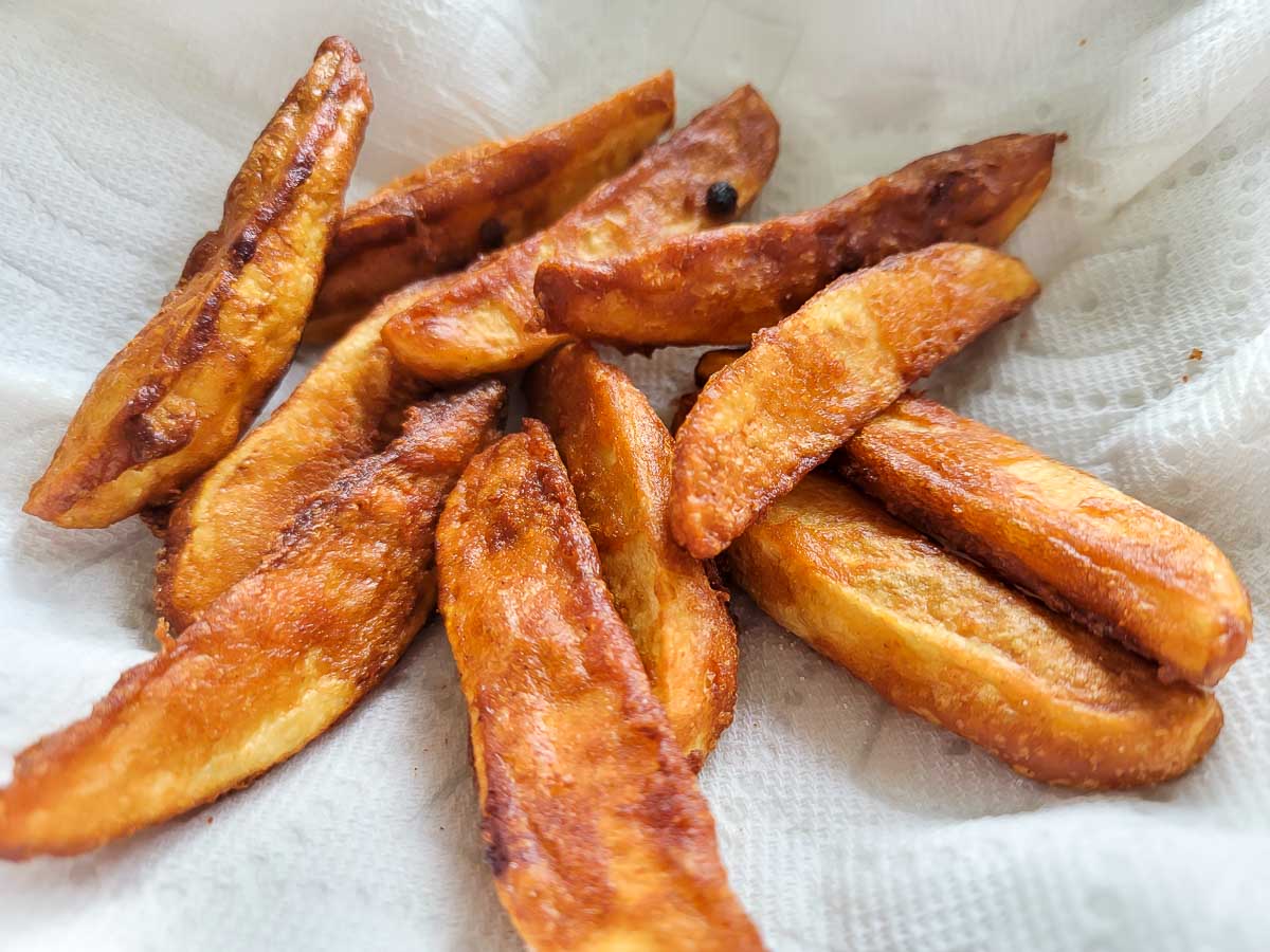 Battered Potato Wedges on paper towel.