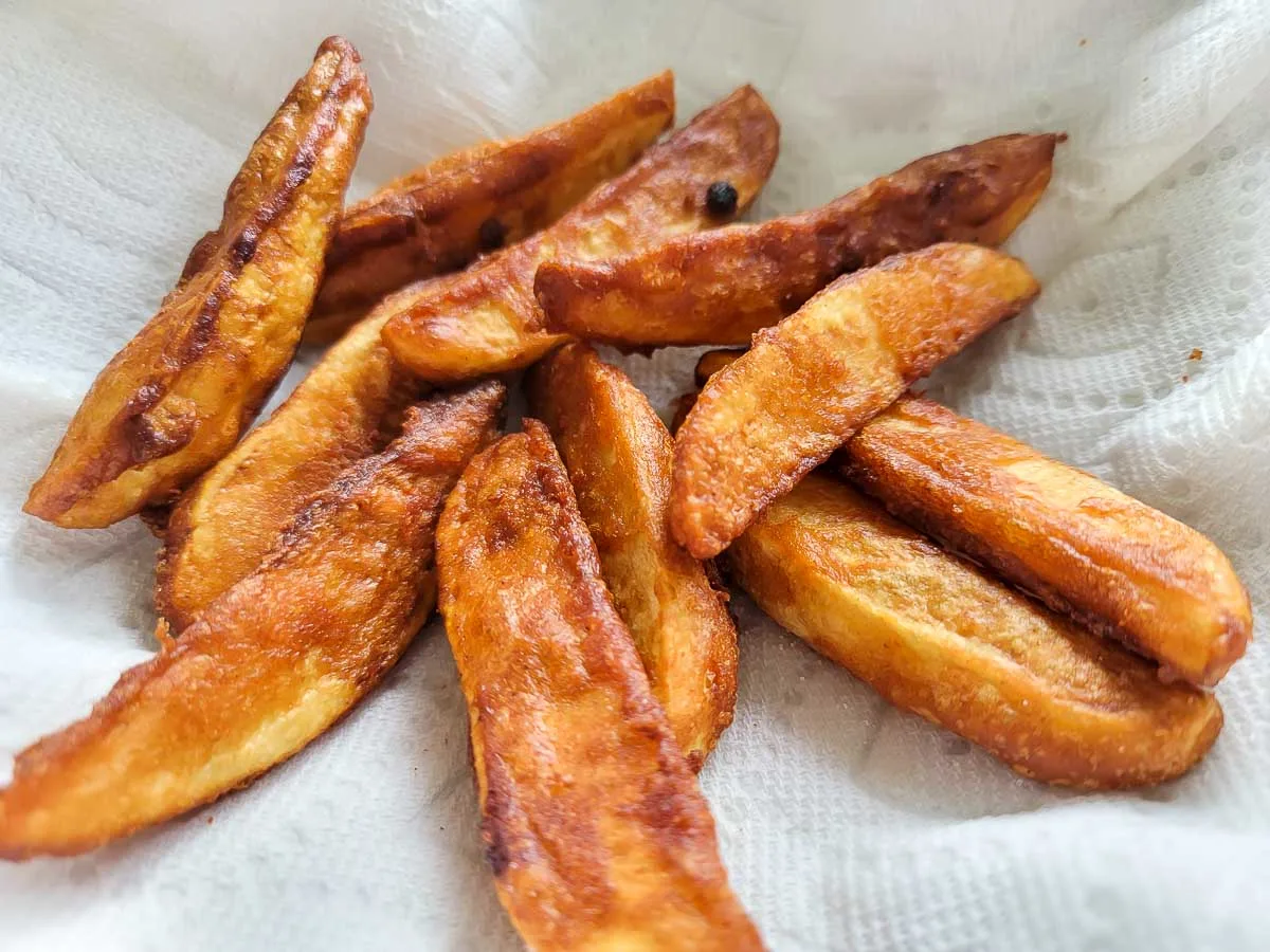 Battered Potato Wedges on paper towel.