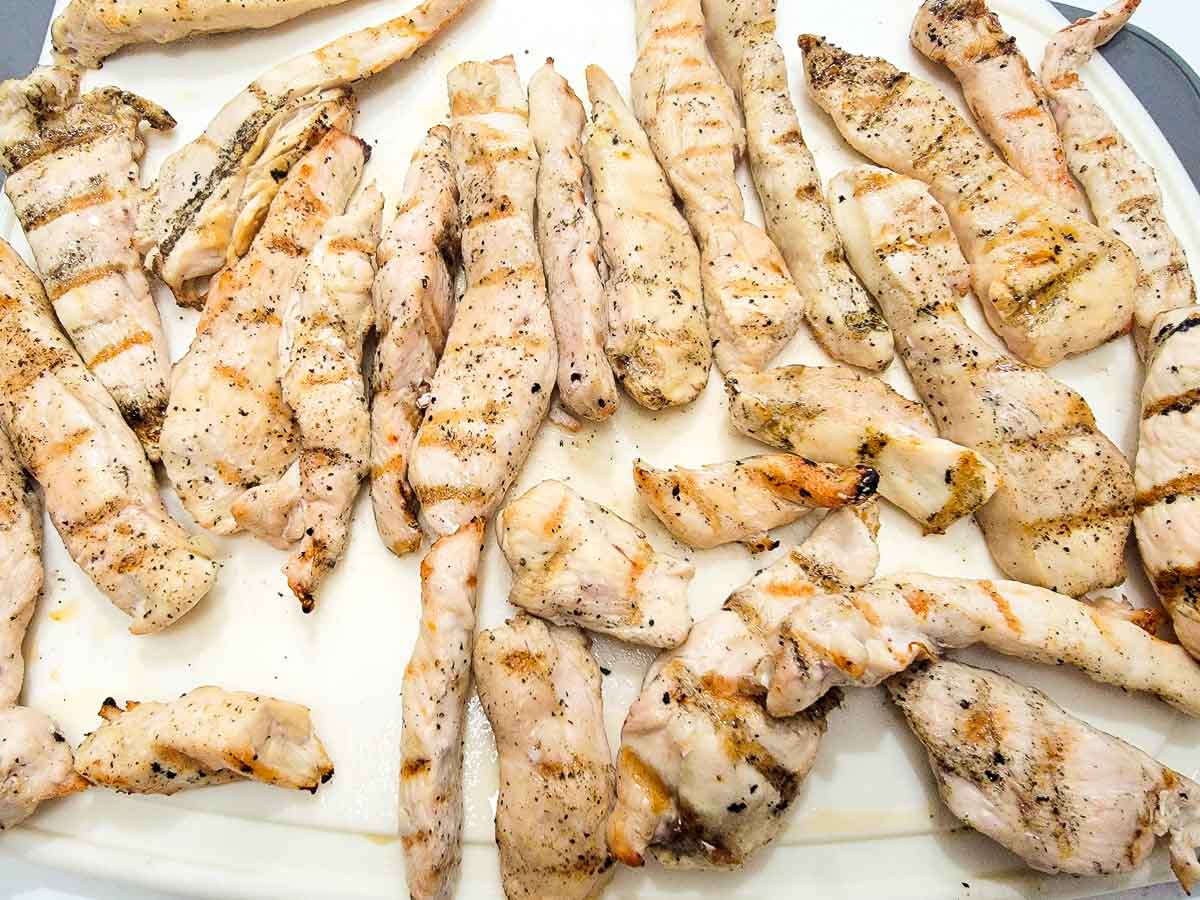 grilled chicken strips on a cutting board.