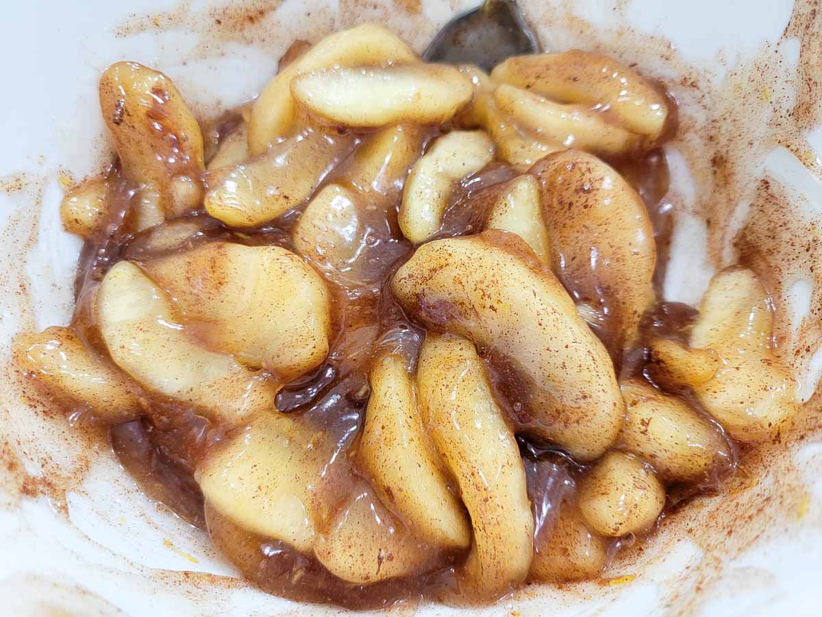 apple pie filling, cinnamon, nutmeg, lemon juice, and lemon zest mixed in a bowl.