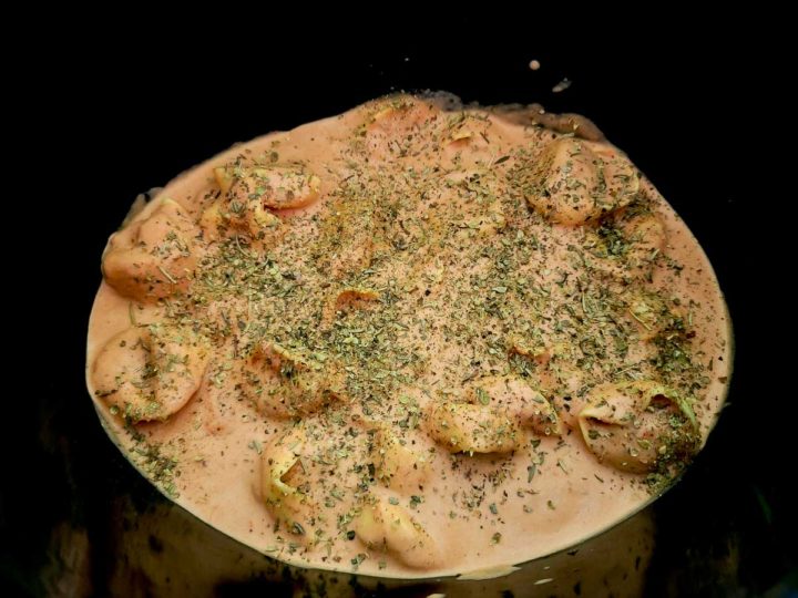 italian seasoning, tortellini, heavy cream, and spaghetti sauce in a crockpot.