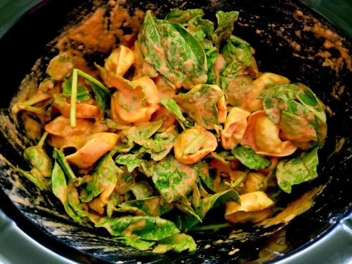 baby spinach, italian seasoning, tortellini, heavy cream, and spaghetti sauce in a crockpot.
