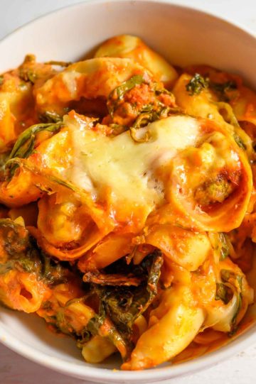 Crockpot Tortellini with spinach in a serving bowl.