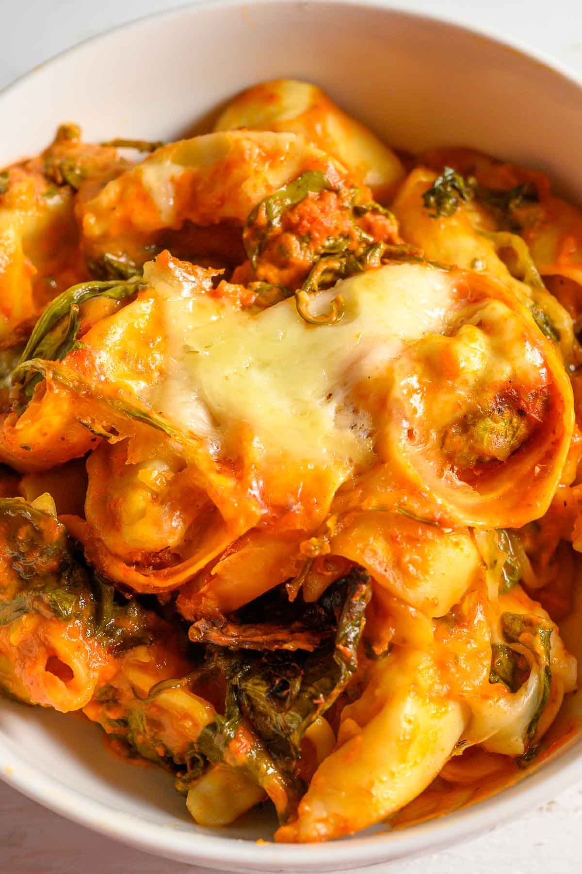 Crockpot Tortellini with spinach in a serving bowl.