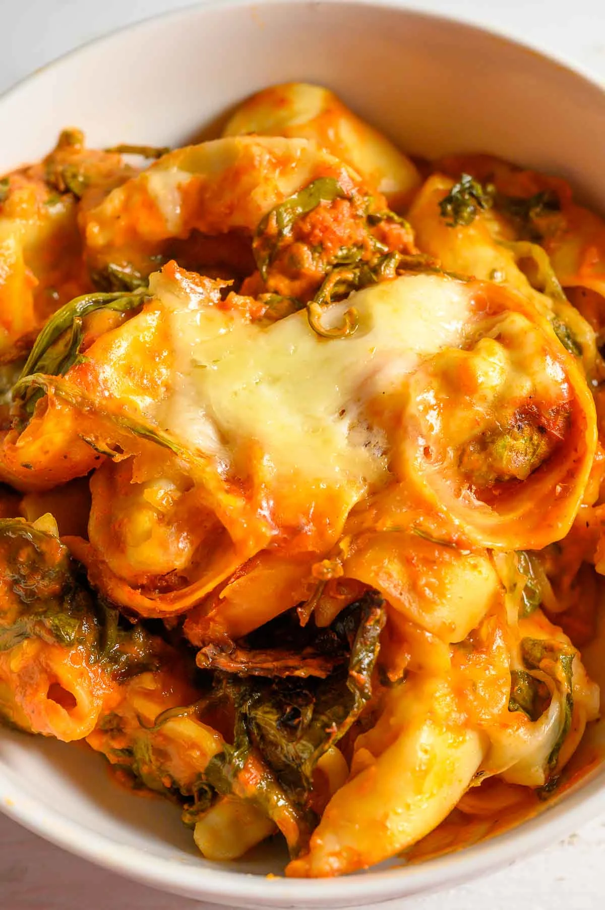 Crockpot Tortellini with spinach in a serving bowl.