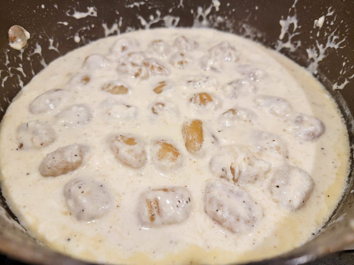 potato gnocchi cooking in a cream sauce.