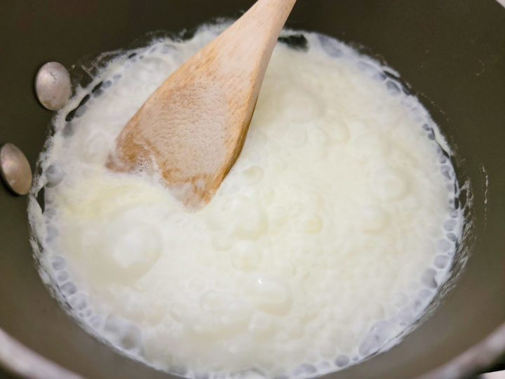 heavy cream simmering in a pan.