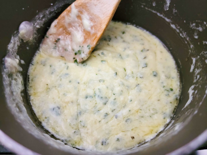 creamy basil and parmesan cheese sauce cooking in a pan.