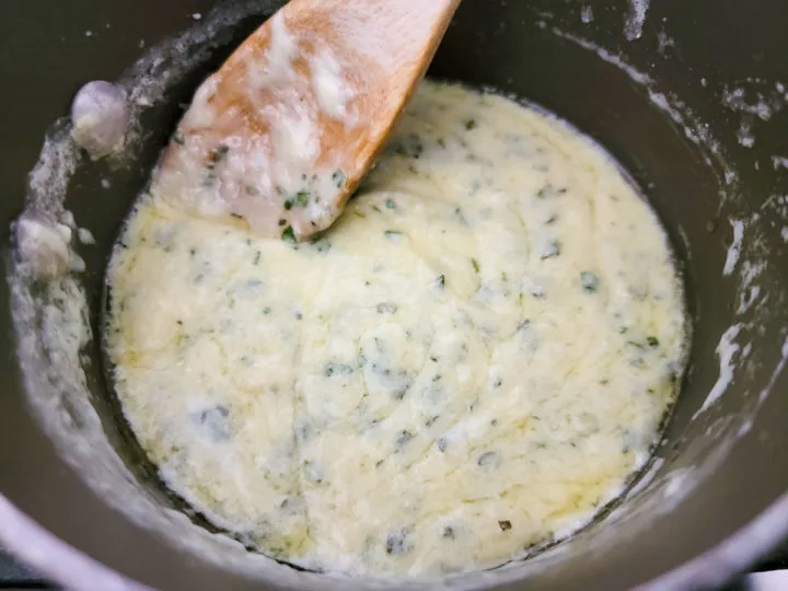 creamy basil and parmesan cheese sauce cooking in a pan.