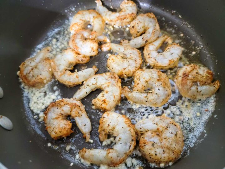 seasoned shrimp frying in butter and garlic.