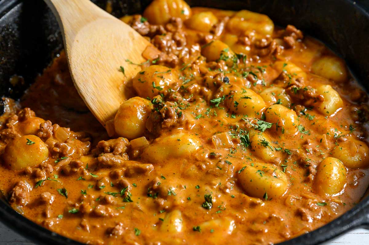 cheeseburger gnocchi cooking in a skillet.