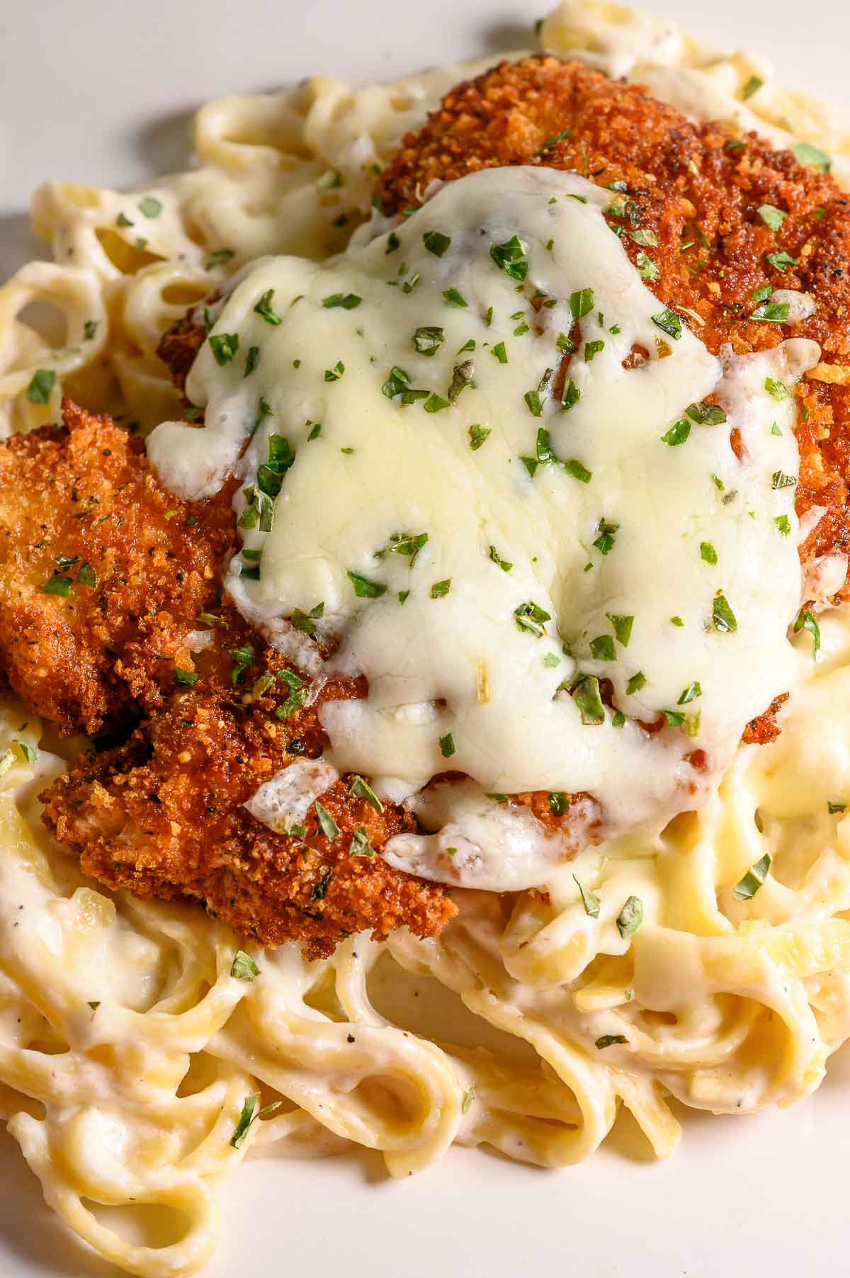 crispy panko fried chicken over pasta and topped with melted cheese.