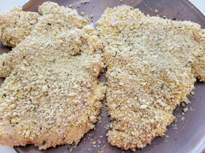 crispy panko breaded chicken uncooked on a plate.
