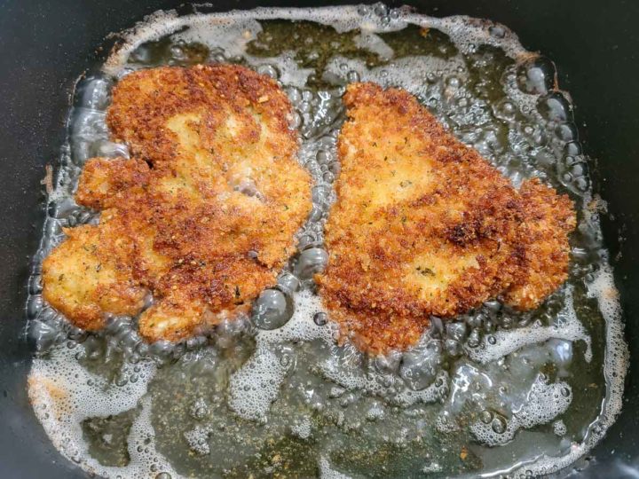crispy panko breaded chicken frying in oil.